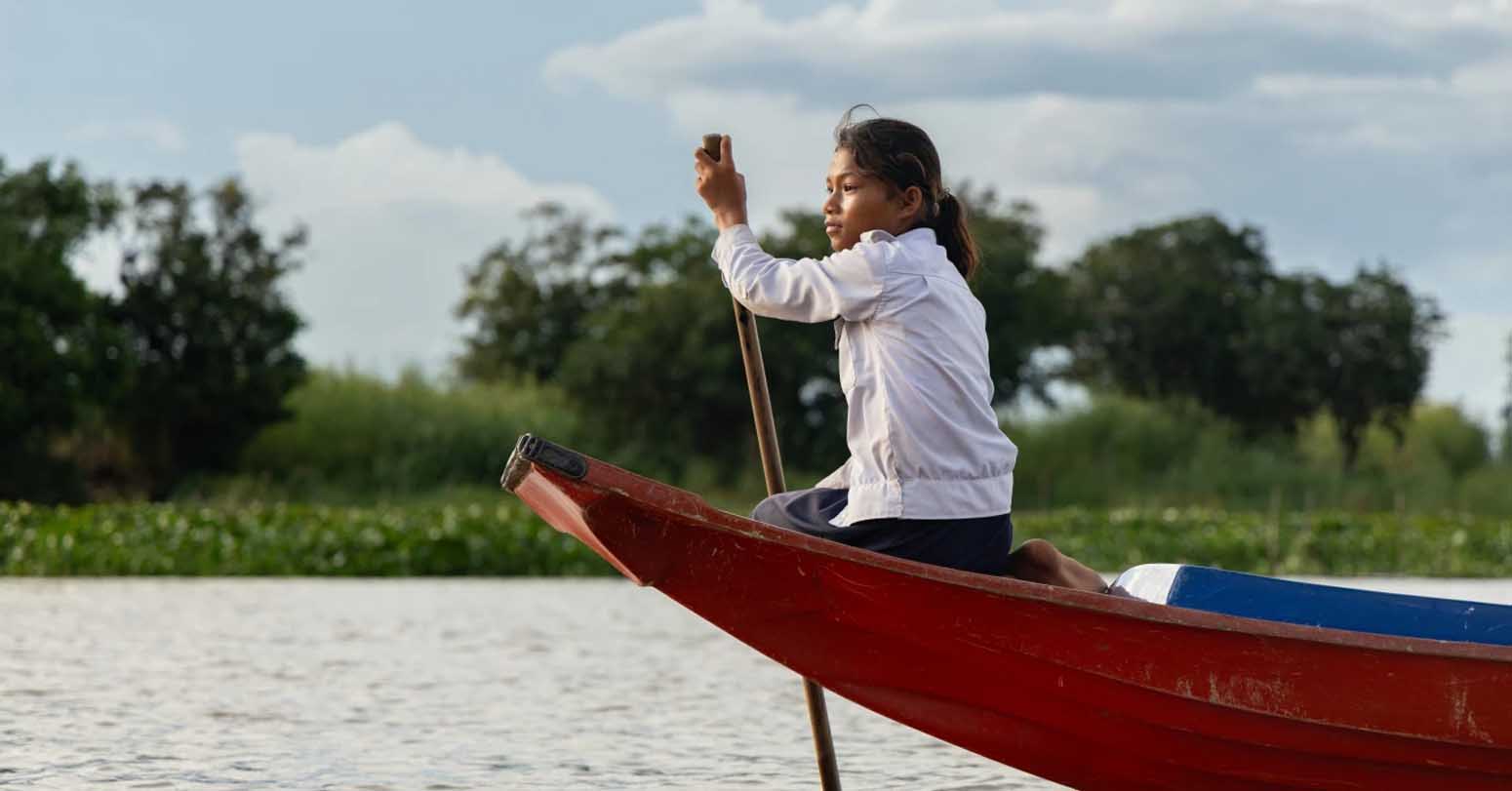 Student From A Floating Village Steers A School Boat On Tonle Sap Lake